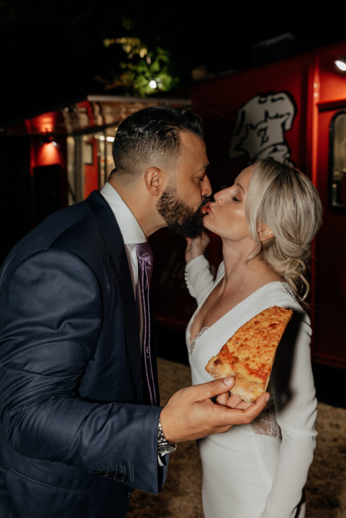newlyweds kissing with pizza
